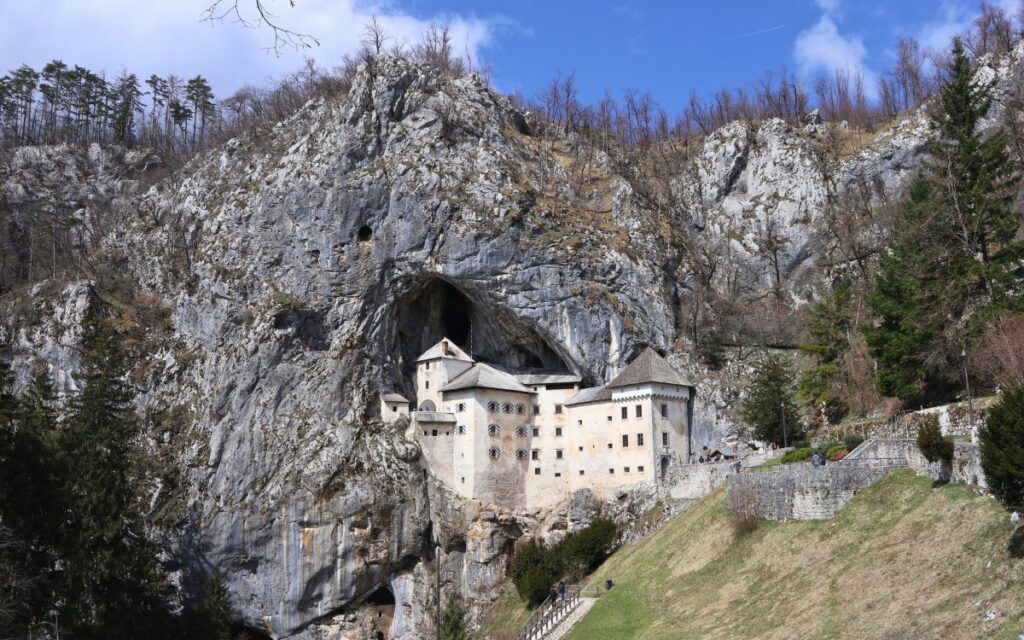 Die beeindruckende Höhlenburg Predjama in Slowenien, die direkt in eine senkrechte Felswand gebaut wurde – Sehenswürdigkeit nahe der Postojna-Höhlen.